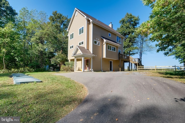 119 Bald Eagle Dr, Montross, VA 22520 - view of property exterior with a chimney, a lawn, a deck, fence, and aphalt driveway