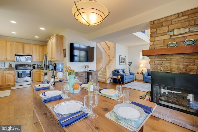 119 Bald Eagle Dr, Montross, VA 22520 - dining room featuring recessed lighting, light wood-type flooring, stairs, and a stone fireplace