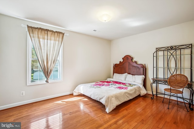 bedroom featuring baseboards and hardwood / wood-style floors
