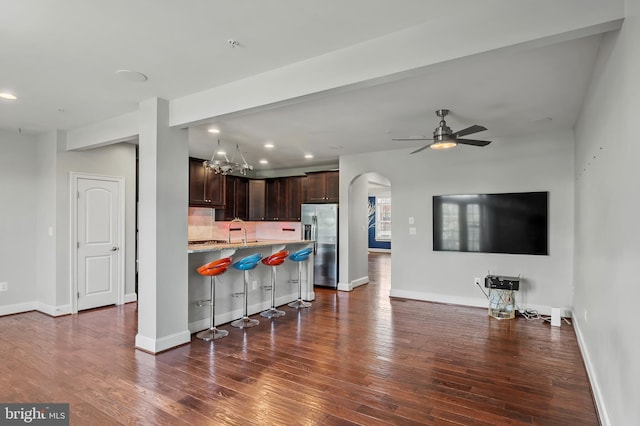 15343 Tewkesbury Pl, Upper Marlboro, MD 20774 - kitchen featuring stainless steel fridge, open floor plan, a kitchen bar, dark brown cabinetry, and dark wood-style flooring