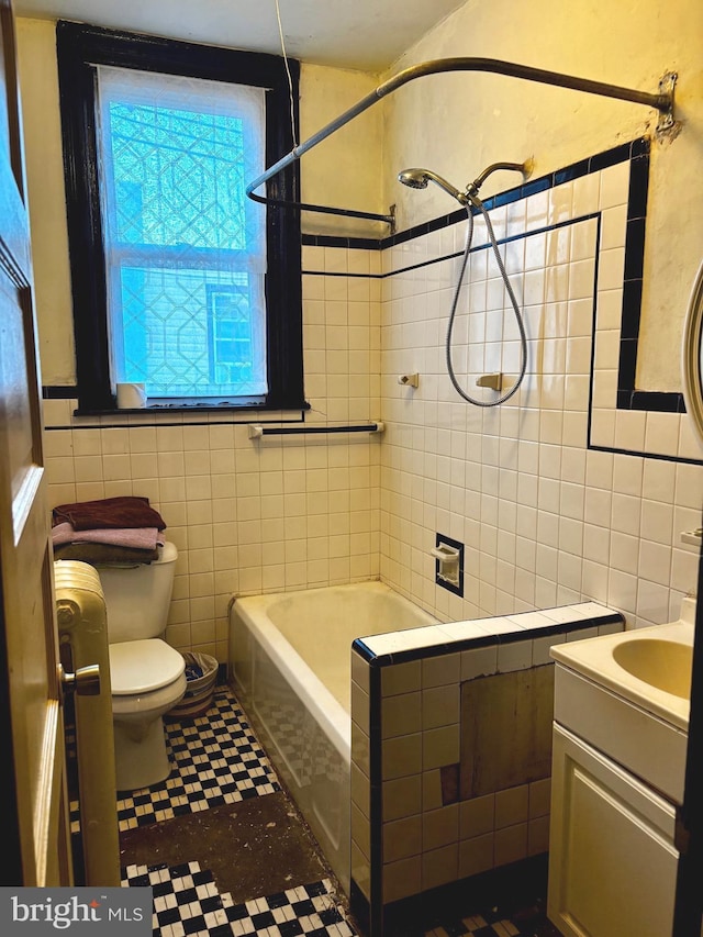 bathroom featuring toilet, shower / bath combination, tile walls, and vanity