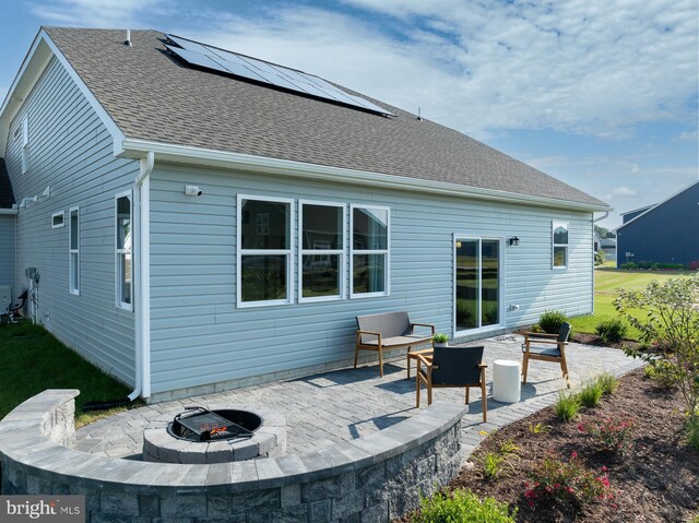 35247 Duck Haven Rd, Selbyville, DE 19975 - rear view of property with a patio, solar panels, an outdoor fire pit, a yard, and a shingled roof