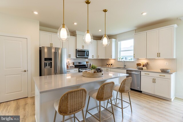 35247 Duck Haven Rd, Selbyville, DE 19975 - kitchen with tasteful backsplash, white cabinets, appliances with stainless steel finishes, light wood finished floors, and a sink