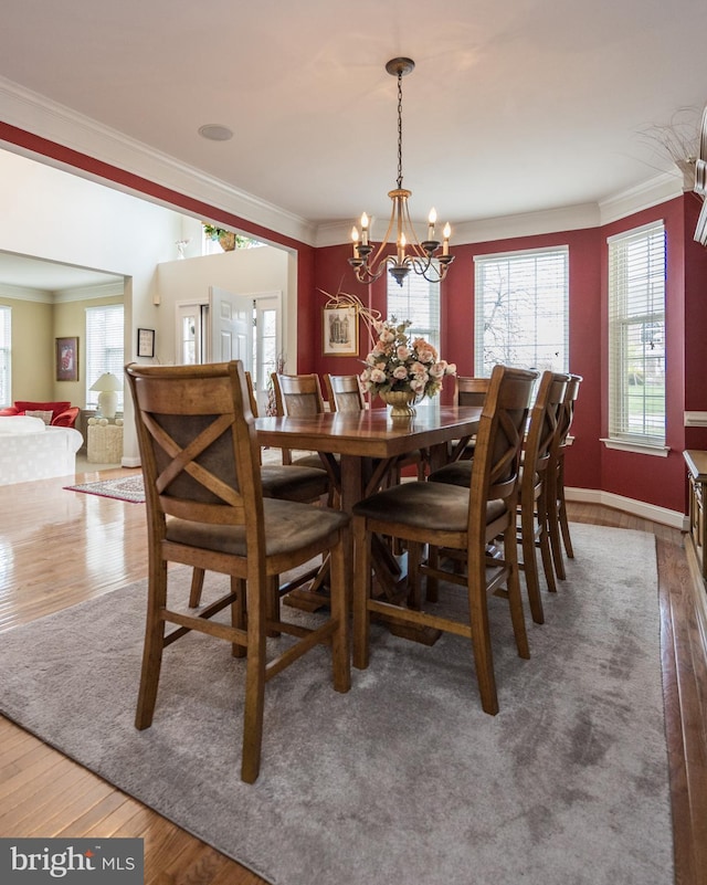 dining room with ornamental molding, plenty of natural light, and wood finished floors