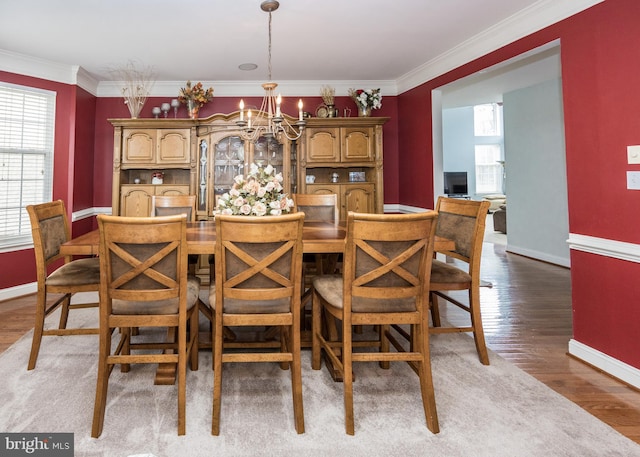 dining space featuring an inviting chandelier, baseboards, and ornamental molding