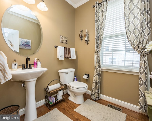 bathroom with visible vents, baseboards, ornamental molding, and wood finished floors