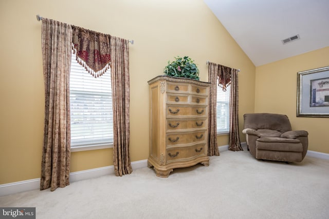 sitting room with visible vents, a wealth of natural light, light colored carpet, and vaulted ceiling