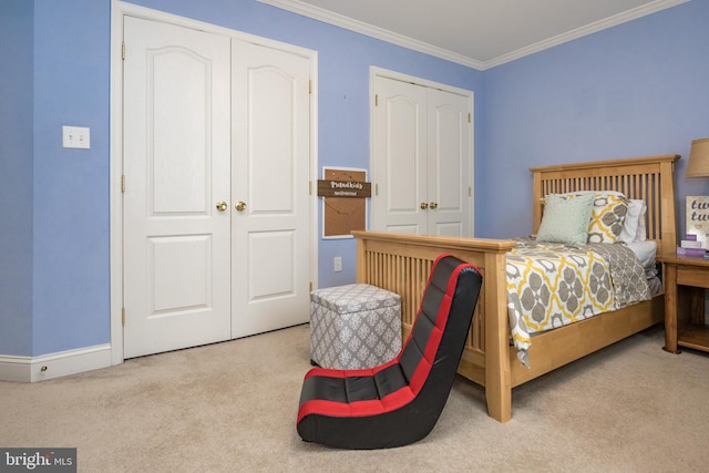 carpeted bedroom featuring crown molding and baseboards