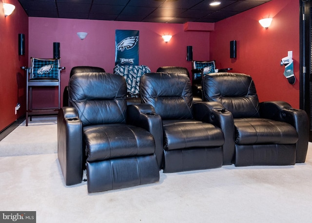 carpeted home theater with a drop ceiling