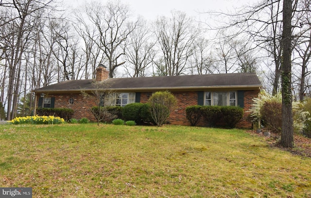 ranch-style house featuring brick siding, a front lawn, and a chimney