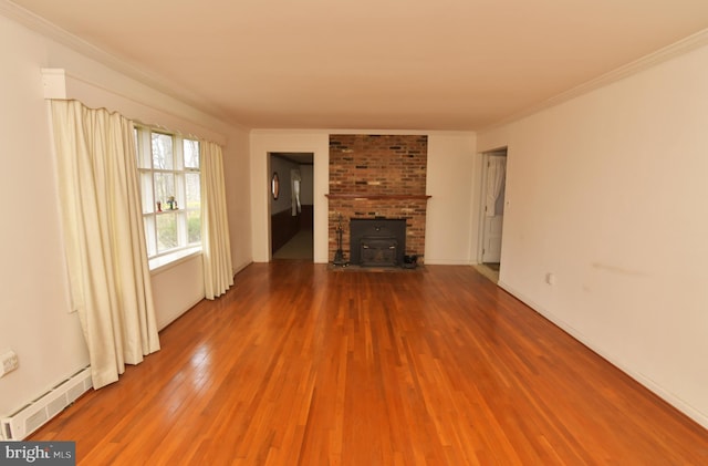 unfurnished living room with a wood stove, baseboard heating, ornamental molding, and wood finished floors