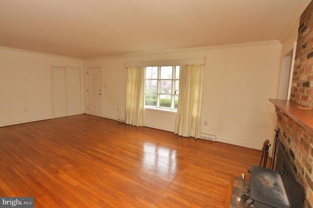 unfurnished living room with visible vents, ornamental molding, wood finished floors, and a fireplace