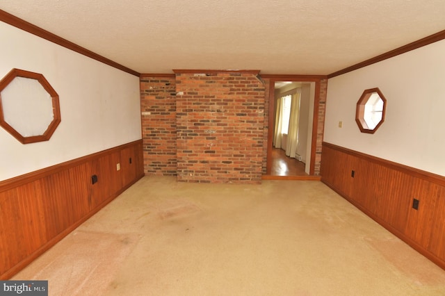 unfurnished room with a textured ceiling, wooden walls, and a wainscoted wall