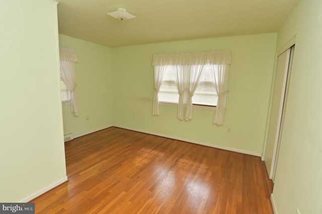 empty room featuring baseboards and wood finished floors