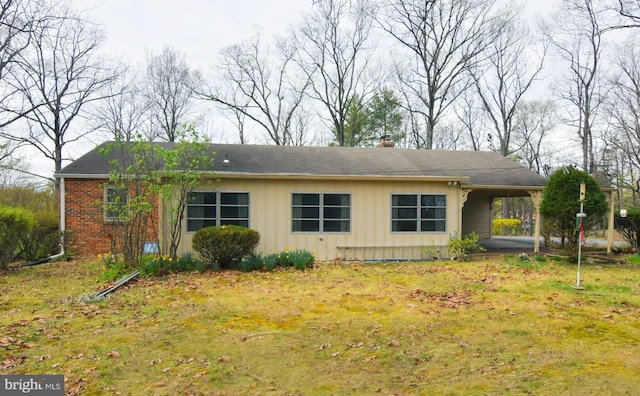 ranch-style house with board and batten siding, a chimney, an attached carport, and a front lawn