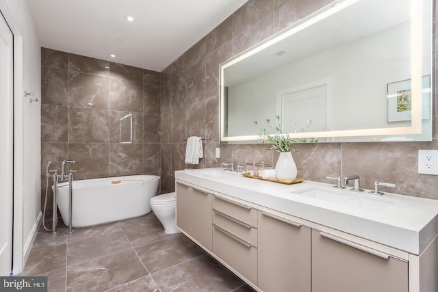 1427 Rhode Island Ave NW Unit 301, Washington, DC 20005 - full bath with tile walls, a freestanding tub, double vanity, tasteful backsplash, and toilet