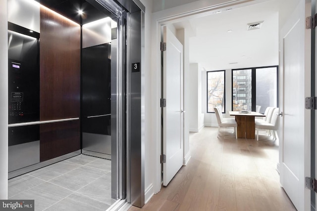 hall featuring elevator and light wood-style floors