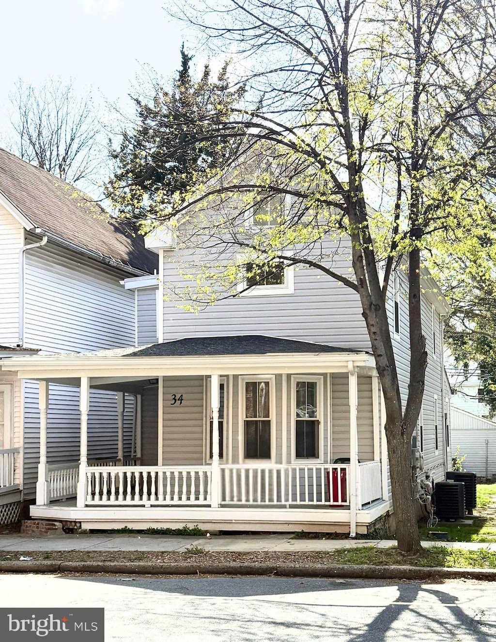 view of front of property featuring central AC unit, roof with shingles, and covered porch