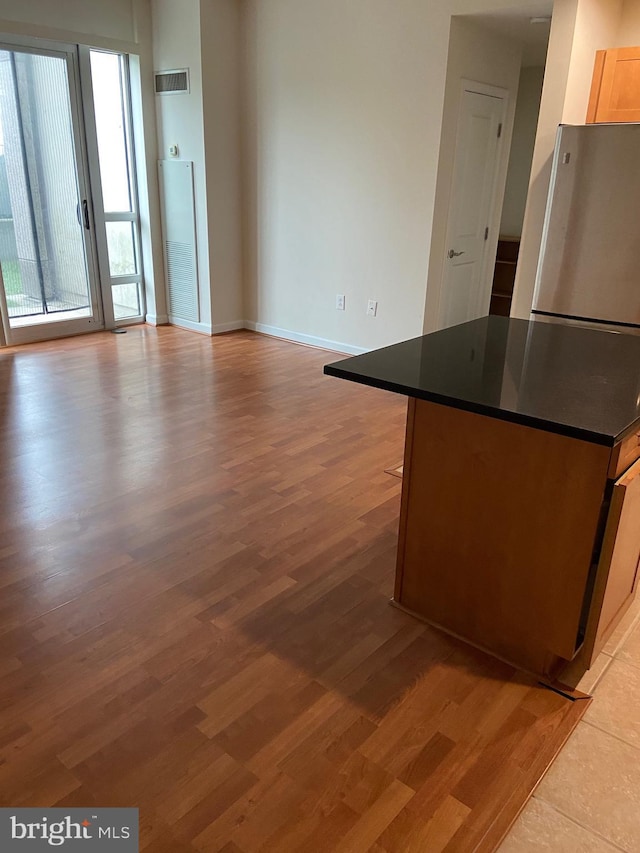 unfurnished living room with baseboards, visible vents, and light wood-type flooring