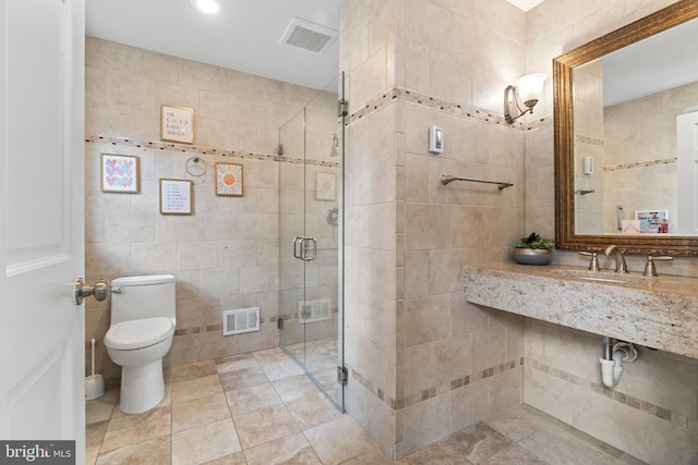 full bathroom featuring toilet, a stall shower, tile walls, and visible vents