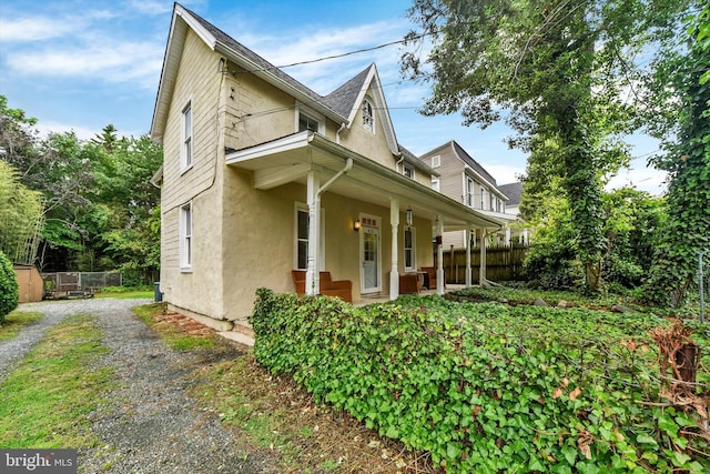 415 Schwartz Ave, Baltimore, MD 21212 - view of side of property with stucco siding, covered porch, and driveway