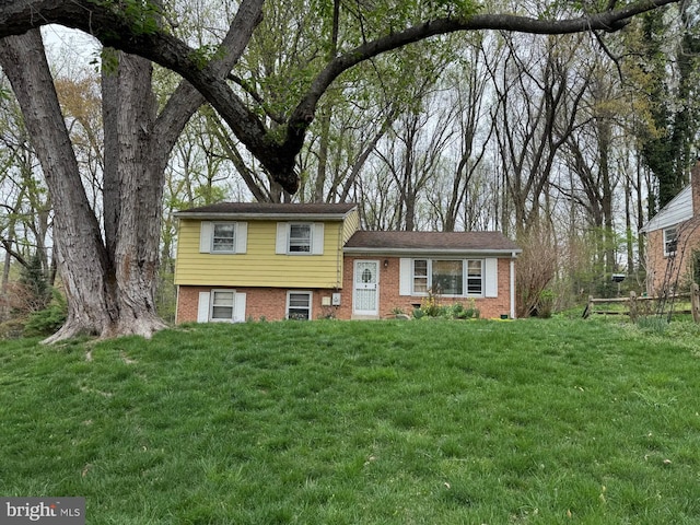 split level home with brick siding and a front lawn