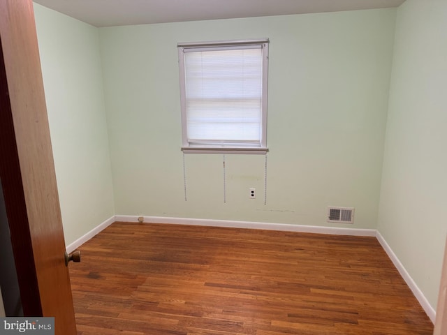 spare room featuring wood finished floors and baseboards