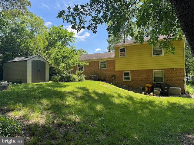 rear view of house with cooling unit, a yard, and brick siding