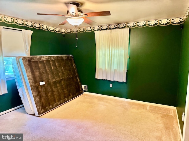 empty room with carpet floors, ceiling fan, and baseboards