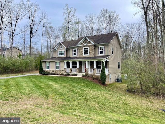 view of front of house with covered porch, a front lawn, cooling unit, and stone siding