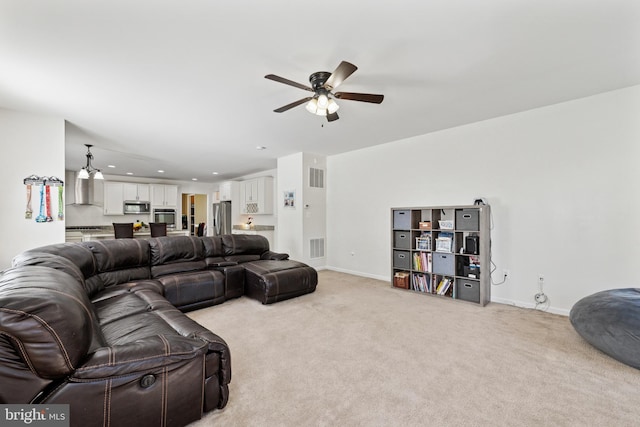living area featuring baseboards, visible vents, a ceiling fan, and light colored carpet