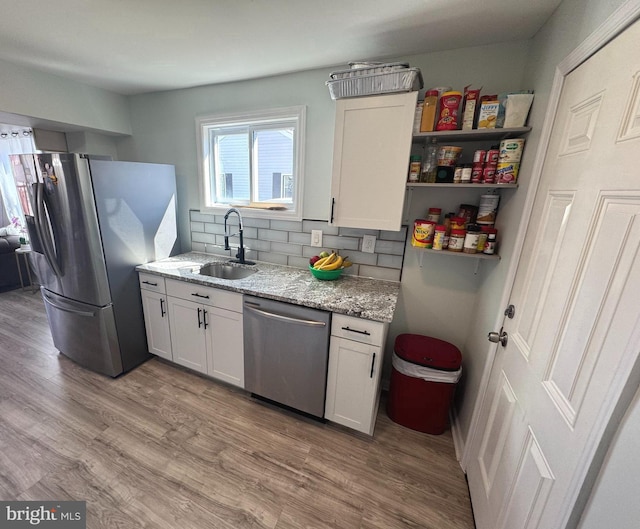3207 Randall Rd, Suitland, MD 20746 - kitchen featuring a sink, appliances with stainless steel finishes, light wood-style floors, and light stone counters