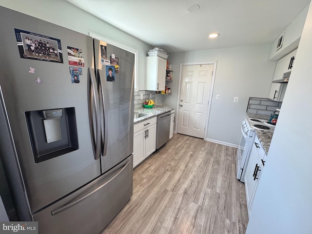 3207 Randall Rd, Suitland, MD 20746 - kitchen with tasteful backsplash, light wood-type flooring, stainless steel appliances, recessed lighting, and white cabinetry