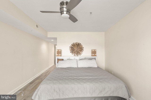 bedroom with visible vents, baseboards, ceiling fan, and wood finished floors