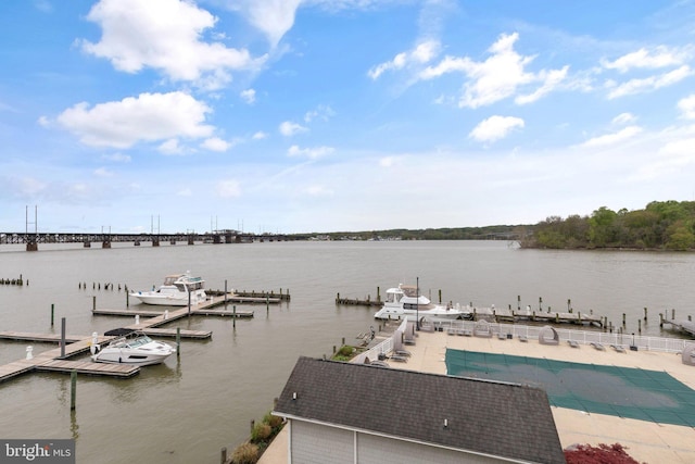 view of dock featuring a water view, a patio, and a fenced in pool
