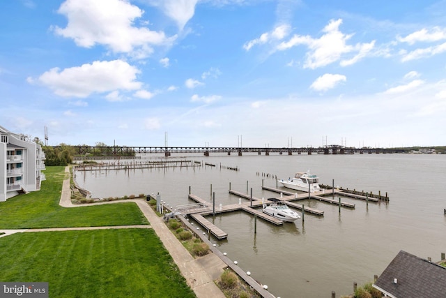 view of dock with a yard and a water view