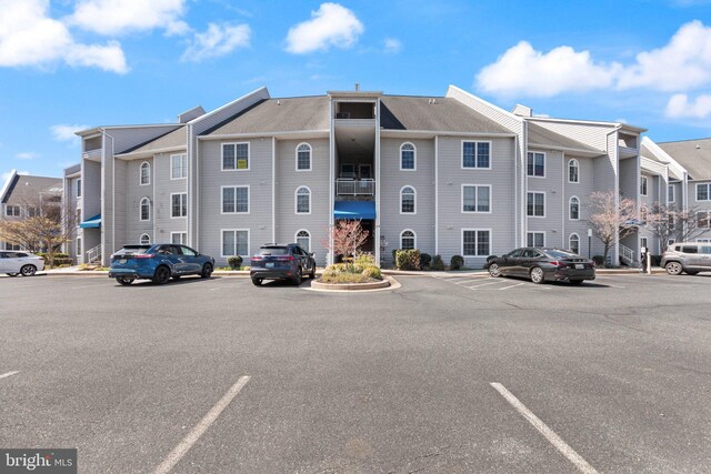 view of property with a residential view and uncovered parking