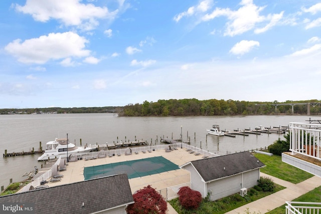 exterior space featuring a dock, fence, a patio, and a water view