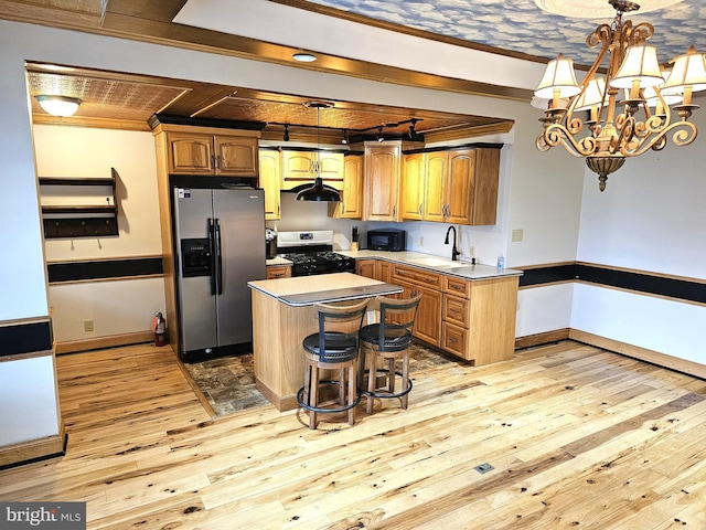 kitchen with light wood-type flooring, stainless steel fridge with ice dispenser, gas stove, a sink, and black microwave