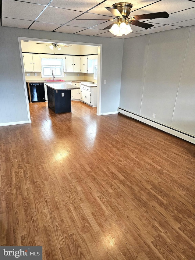 interior space featuring ceiling fan, wood finished floors, a baseboard heating unit, and a paneled ceiling