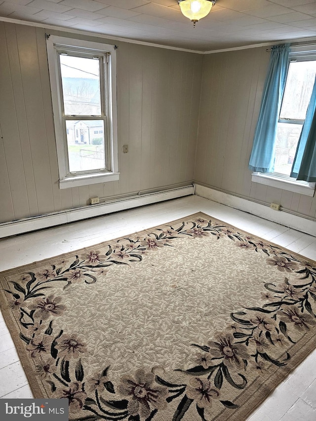 unfurnished room with crown molding and a baseboard heating unit