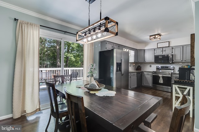 dining space featuring dark wood-style flooring and ornamental molding
