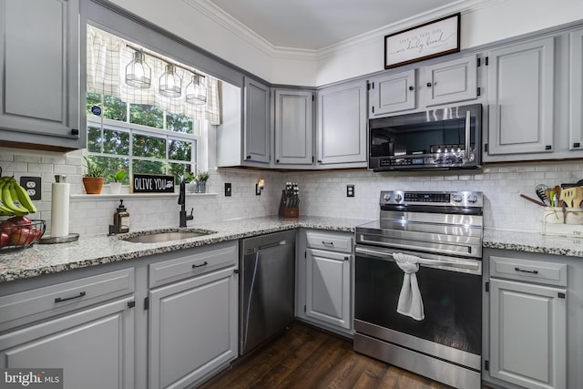 kitchen with stainless steel appliances, a sink, ornamental molding, and gray cabinets