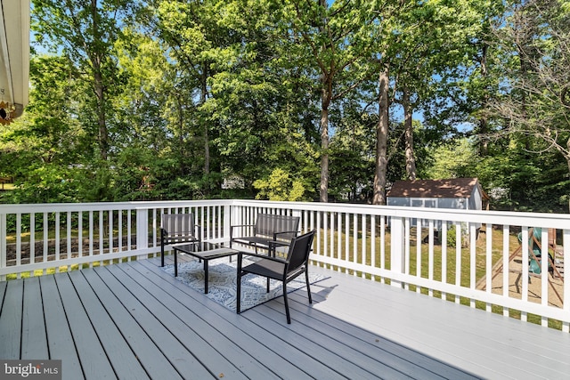 wooden deck with a yard, an outdoor structure, and a shed