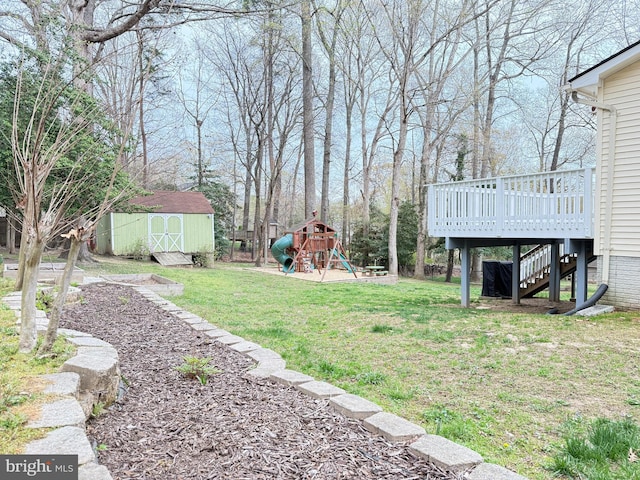 view of yard featuring stairs, a deck, a shed, an outbuilding, and a playground