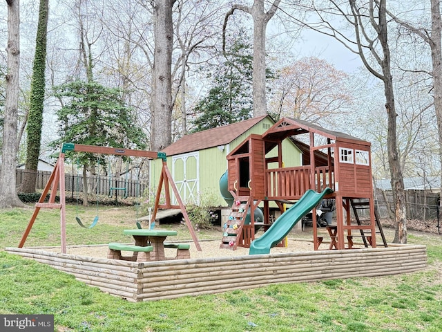 view of jungle gym with a lawn, an outdoor structure, fence, and a shed