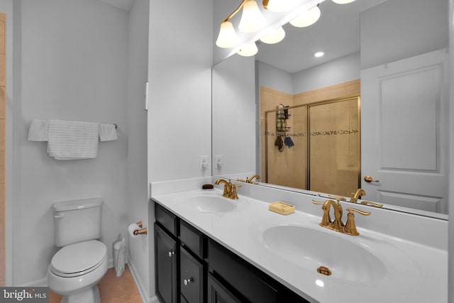 bathroom with a sink, a shower stall, double vanity, and toilet
