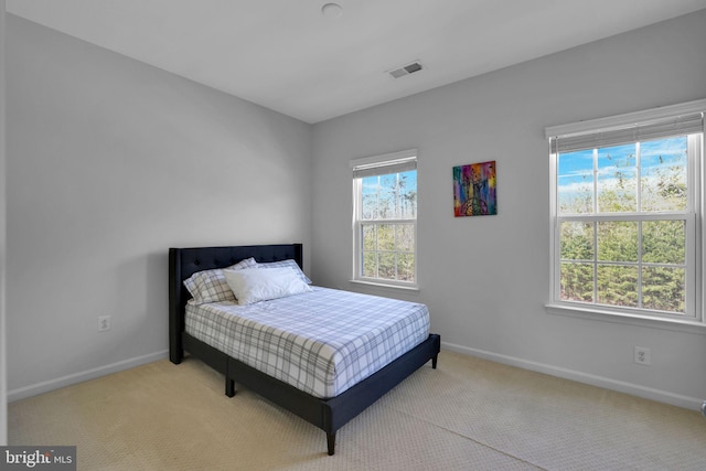 carpeted bedroom featuring baseboards and visible vents