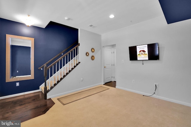 unfurnished living room featuring recessed lighting, visible vents, carpet floors, baseboards, and stairs