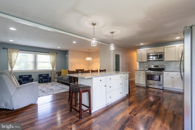 3305 Baker Ct, Altoona, PA 16602 - kitchen with appliances with stainless steel finishes, open floor plan, dark wood-style flooring, a breakfast bar area, and recessed lighting